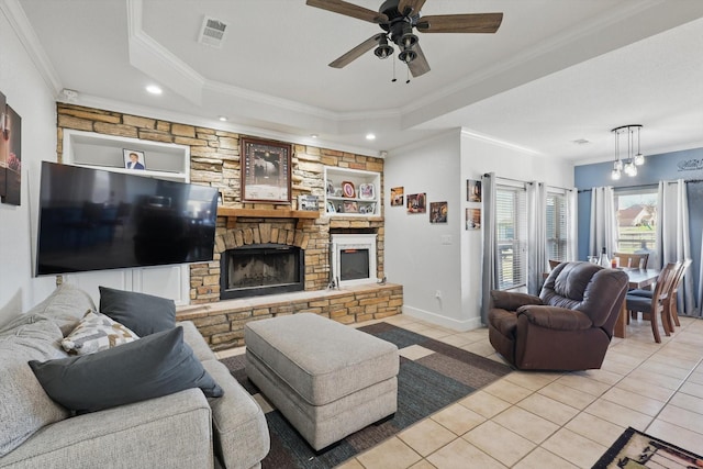 living area with light tile patterned floors, visible vents, a fireplace, and a tray ceiling