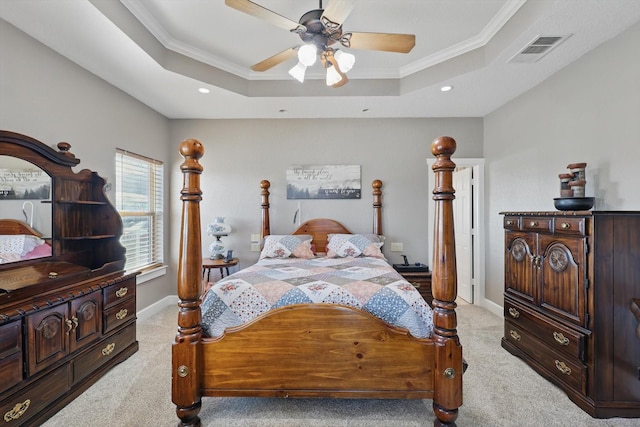 bedroom featuring a tray ceiling, ornamental molding, visible vents, and light carpet