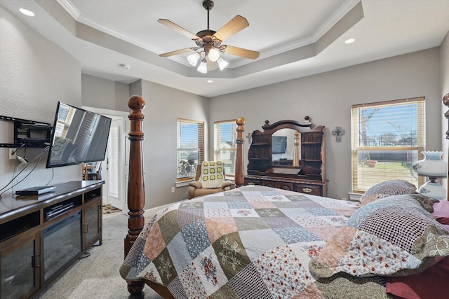 bedroom with light carpet, a raised ceiling, a ceiling fan, and ornamental molding