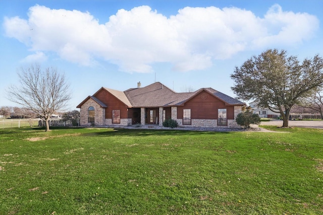 view of front facade with stone siding and a front lawn