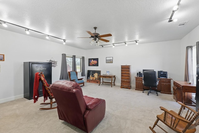 office space featuring track lighting, light colored carpet, and a textured ceiling