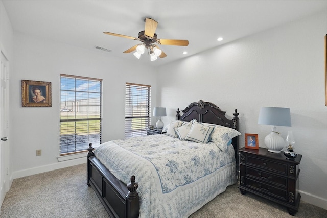 bedroom with a ceiling fan, baseboards, visible vents, and light carpet