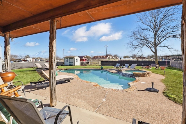 view of pool featuring an outbuilding, a patio, a fenced backyard, a shed, and a yard