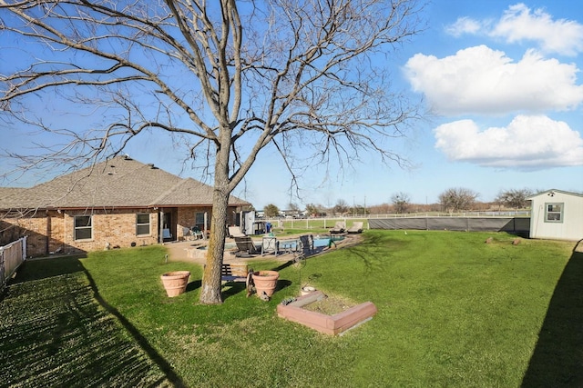 view of yard featuring a patio, a fenced backyard, a fenced in pool, and an outdoor structure