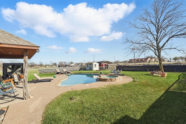 view of pool with an outbuilding, a fenced backyard, a yard, a storage shed, and a patio area