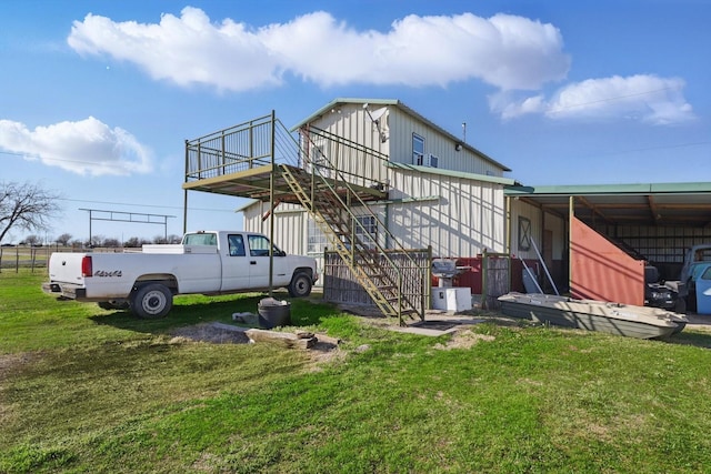 back of house featuring a yard and stairs