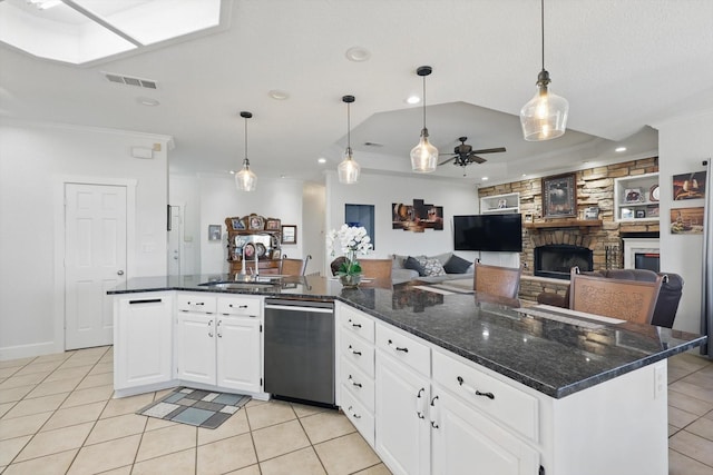 kitchen featuring visible vents, dishwasher, light tile patterned floors, a fireplace, and a sink