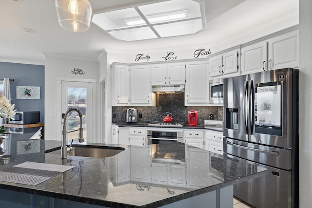 kitchen with under cabinet range hood, backsplash, appliances with stainless steel finishes, and a sink