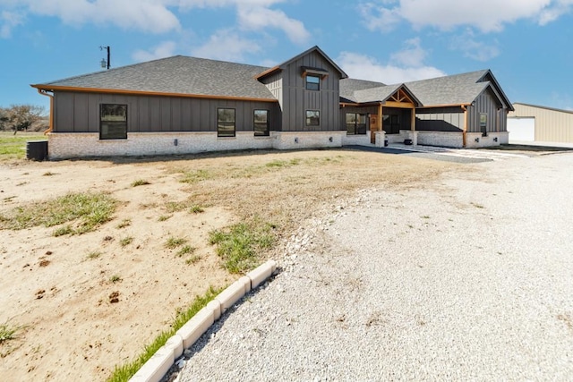 back of property with board and batten siding and roof with shingles