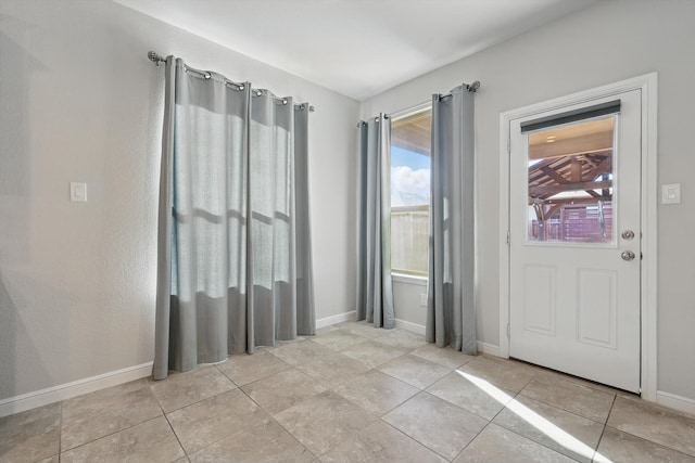 interior space with light tile patterned flooring and baseboards