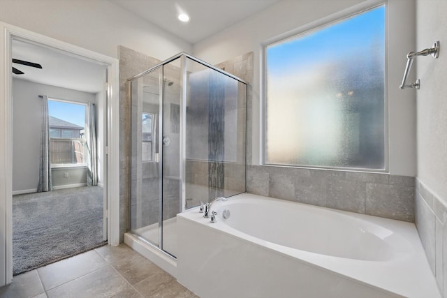 full bathroom featuring tile patterned floors, a bath, and a stall shower