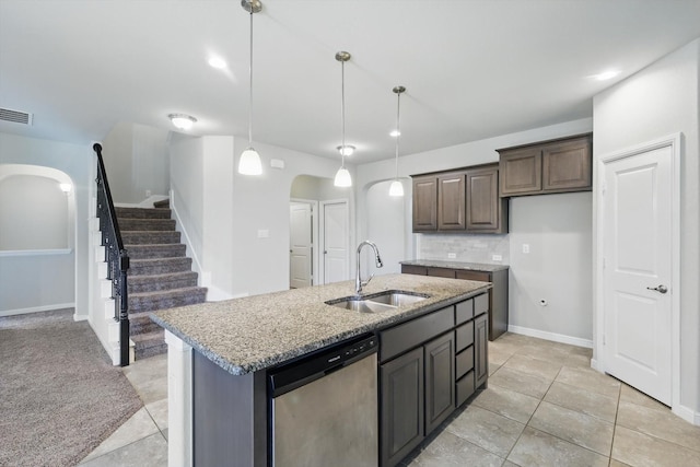 kitchen with light stone countertops, decorative backsplash, stainless steel dishwasher, arched walkways, and a sink