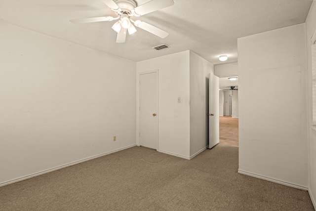 carpeted empty room featuring visible vents, baseboards, and ceiling fan