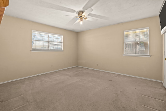 spare room with a ceiling fan, baseboards, carpet floors, and a textured ceiling