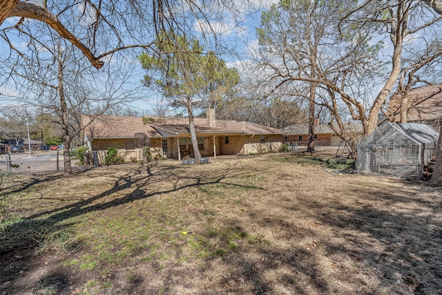 view of yard with a greenhouse, an outdoor structure, and fence