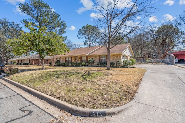 ranch-style home featuring brick siding and a front yard