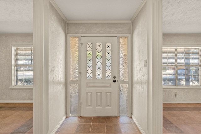 entryway featuring tile patterned flooring, a textured ceiling, baseboards, and ornamental molding