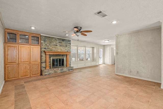 unfurnished living room with visible vents, ornamental molding, ceiling fan, a textured ceiling, and a brick fireplace