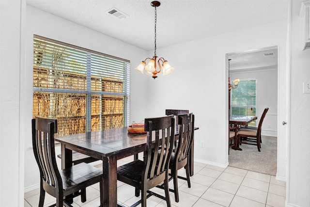 dining space with a chandelier, visible vents, a textured ceiling, and light tile patterned flooring