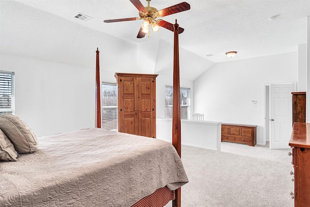 carpeted bedroom with visible vents, lofted ceiling, a textured ceiling, and a ceiling fan