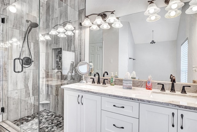 bathroom with double vanity, a stall shower, lofted ceiling, and a sink