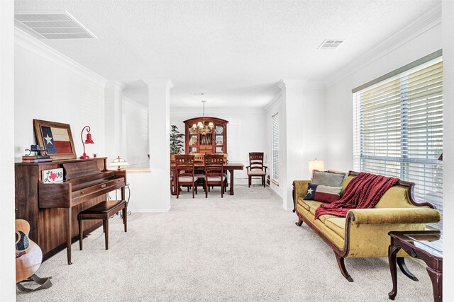 living area with visible vents, carpet, an inviting chandelier, and ornamental molding