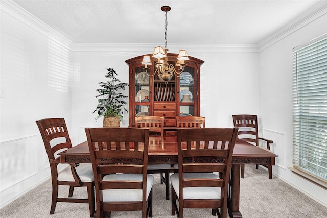 dining space featuring a chandelier, crown molding, and carpet