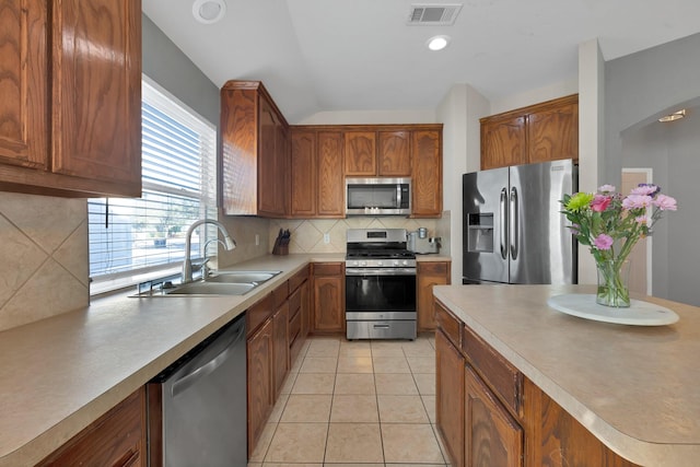 kitchen with visible vents, light tile patterned floors, decorative backsplash, stainless steel appliances, and a sink