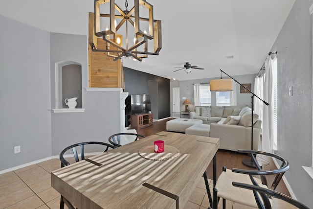 tiled dining area with ceiling fan with notable chandelier, visible vents, and baseboards