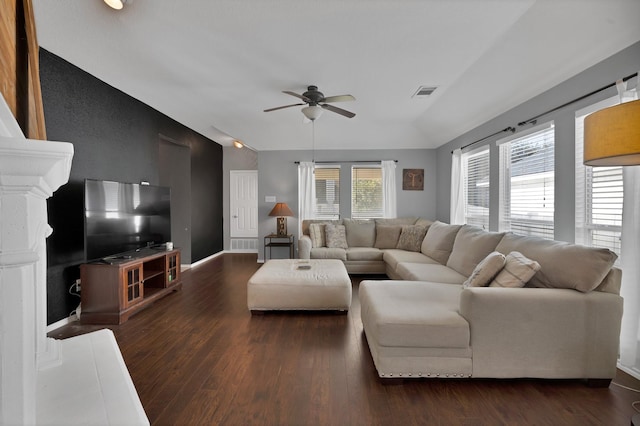 living area with visible vents, ceiling fan, baseboards, lofted ceiling, and dark wood-style flooring