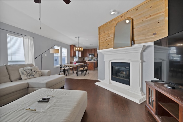 living room featuring ceiling fan, recessed lighting, a glass covered fireplace, and dark wood-style flooring