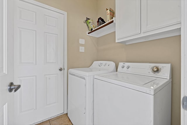 clothes washing area with cabinet space, light tile patterned flooring, and separate washer and dryer