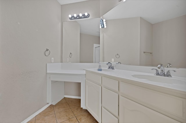 full bathroom featuring tile patterned flooring, double vanity, baseboards, and a sink