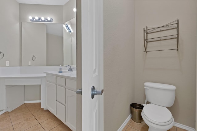 bathroom with tile patterned floors, baseboards, toilet, and vanity