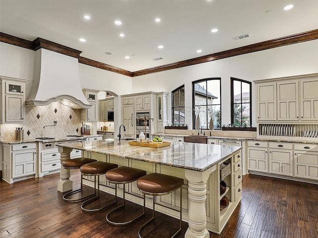 kitchen with a spacious island, visible vents, tasteful backsplash, dark wood-type flooring, and premium range hood