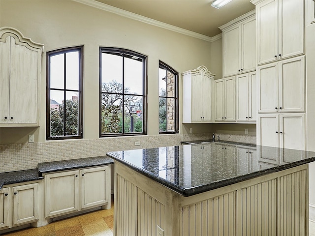 kitchen featuring a kitchen island, dark stone counters, and ornamental molding