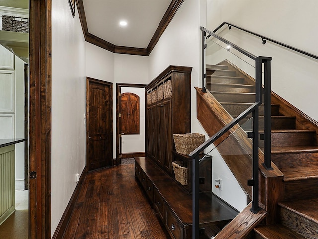 interior space featuring stairway, ornamental molding, baseboards, and dark wood-style flooring