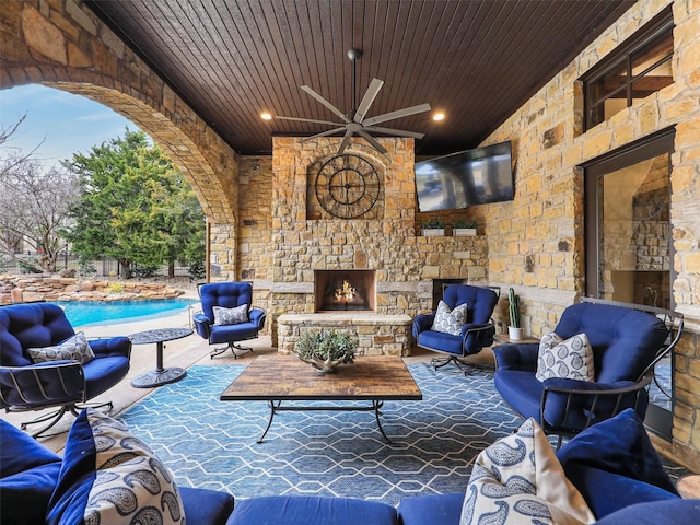 view of patio with a fenced in pool, a ceiling fan, and an outdoor living space with a fireplace