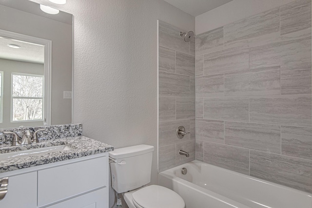 full bath featuring toilet, vanity, bathing tub / shower combination, and a textured wall