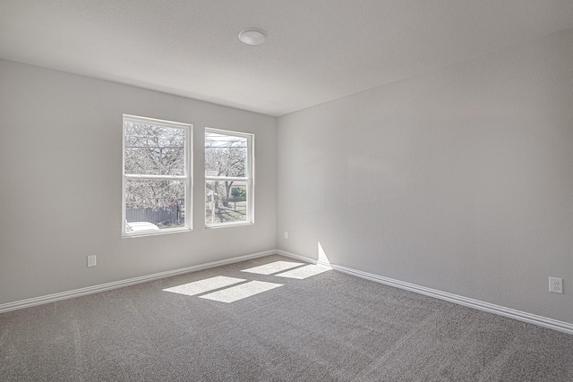 unfurnished room with carpet flooring and baseboards