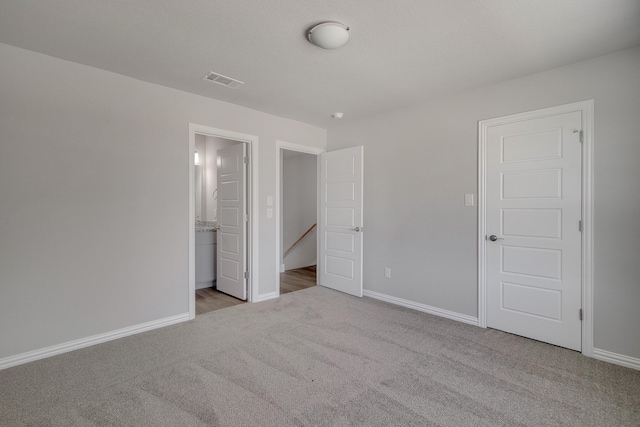 unfurnished bedroom featuring visible vents, carpet floors, and baseboards