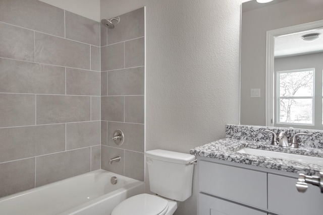 full bathroom featuring shower / bathing tub combination, toilet, vanity, and a textured wall