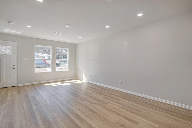 empty room with visible vents, recessed lighting, light wood-type flooring, and baseboards