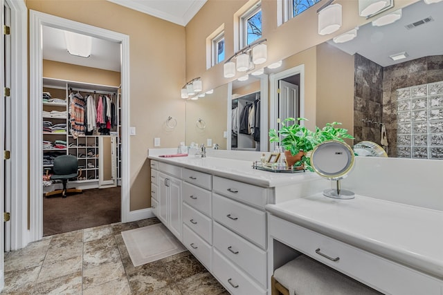 bathroom with visible vents, a walk in closet, baseboards, walk in shower, and vanity