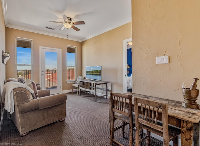 living room featuring crown molding, visible vents, dark carpet, and ceiling fan