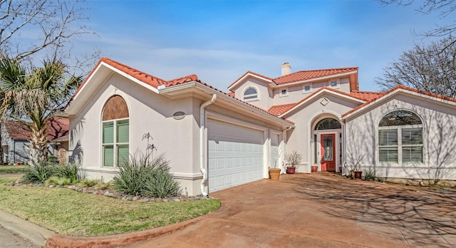 mediterranean / spanish-style home featuring stucco siding, a garage, a chimney, and a tiled roof