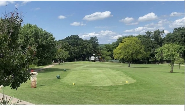 view of community with a yard and view of golf course