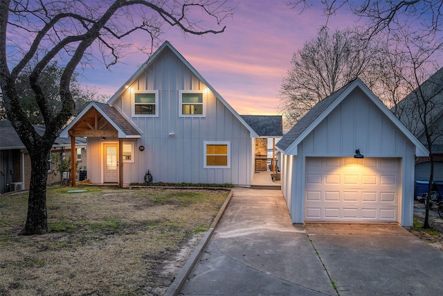 view of front of property with concrete driveway, board and batten siding, a detached garage, and a shingled roof