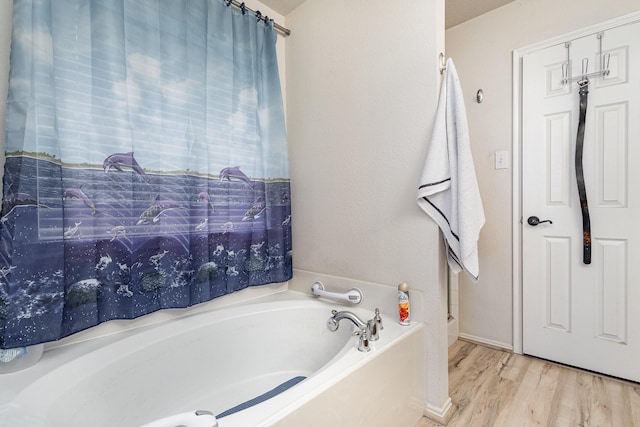 bathroom featuring a bath and wood finished floors