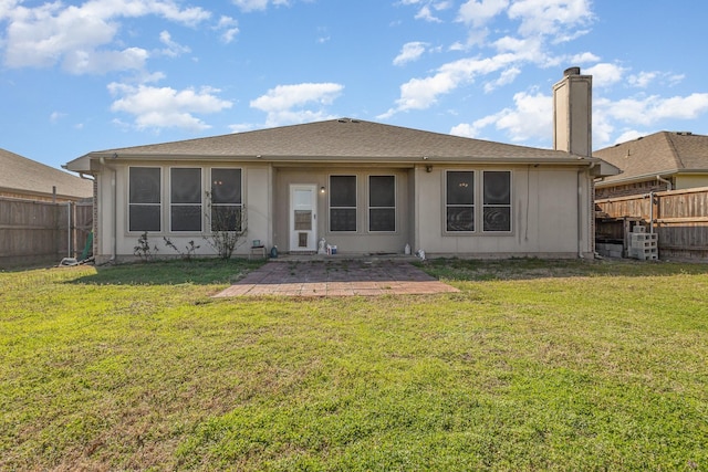 back of property featuring a lawn, a fenced backyard, and a chimney